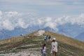 Monte Baldo, Italy - August 8, 2019: Tourists hikers walk on top of monte baldo with heavy fog in the background