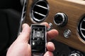The new Rolls Royce Cullinan wireless keys in male hand. Interior with natural wood panel. Rolls-Royce Cullinan luxury SUV wireles Royalty Free Stock Photo