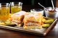 monte cristo sandwich with pickles and chips on a tray