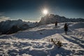 Monte Piana, Italy - January 1, 2019 : silhouette of women hiking in scenic snowy dolomites mountains, with direct sunlight