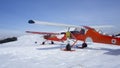 Monte Pora, Bergamo, Italy. A single engined, general aviation red light aircraft parked on a snow covered plateau. Italian Alps