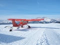 Monte Pora, Bergamo, Italy. A single engined, general aviation red light aircraft on a snow covered plateau is taking off