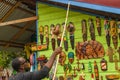 Young male vendor selling wall art wood carvings at craft market Royalty Free Stock Photo