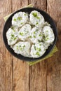 Montenegrin cuisine Kuvana Krtola boiled potatoes with curd yoghurt sauce close-up in a bowl. vertical top view