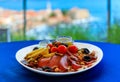 Montenegrin Njeguski prsut and cheese antipasto platter with Budva Old Town and Adriatic Sea in Montenegro in background