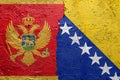 Montenegro and Bosnia and Herzegovina - Cracked concrete wall painted with a Montenegrin flag on the left and a Bosnia flag on the