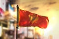 Montenegro Flag Against City Blurred Background At Sunrise Backlight