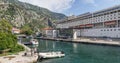 Panorama overlooking the pier on which there is a multi-deck cruise ship with tourists