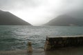 Montenegro port, wavy sea and misty weather. Old wall. Royalty Free Stock Photo