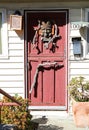Monterey, CA/USA - 9/9/2020: Carved wooden head on a weathered red wooden door, Old Monterey, California.