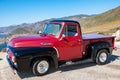 MONTEREY, CALIFORNIA - SEPTEMBER 10, 2015 - Bright red and black classic Ford F-100 parked on the shore of the Pacific ocean, on t