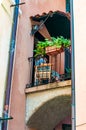Old local woman is sitting on a balcony in Old Town in Monterosso Al Mare, Cinque Terre, Italy