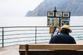 Monterosso, Italy - Apr 8, 2016: Unidentified street artist selling his landscape painting souvenirs by the ocean at Monterosso