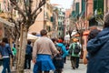 Father and son walk down crowded urban street in small Italian village