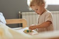 Montessori learning materials. Active playtime fun. Happy childhood memories. Toddler little blonde baby girl palying with wooden