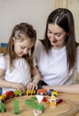 Montessori material. Mom and daughter learn transport through the game. Wooden railroad