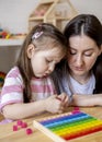 Montessori material. Mom and daughter are studying the colors of the rainbow. Wooden colored cubes Royalty Free Stock Photo