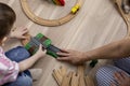 Montessori material. Mom and son learn transport through the game. Wooden railroad. Flat lay