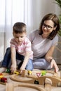 Montessori material. Mom and son learn transport through the game. Wooden railroad