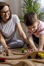 Montessori material. Mom and son learn transport through the game. Wooden railroad