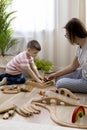 Montessori material. Mom and son learn transport through the game. Wooden railroad