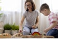 Montessori material. Mom and son learn transport through the game. Wooden railroad