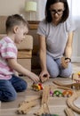 Montessori material. Mom and son learn transport through the game. Wooden railroad