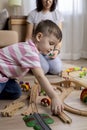 Montessori material. Mom and son learn transport through the game. Wooden railroad