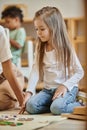 Montessori school, cute girl sitting near