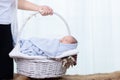 0-1 month Asian newborn baby lie down on basket, baby sleep in white basket wrap up by soft blanket, mother or woman hold the Royalty Free Stock Photo