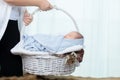 0-1 month Asian newborn baby lie down on basket, baby sleep in white basket wrap up by soft blanket, mother or woman hold the Royalty Free Stock Photo