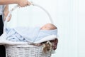 0-1 month Asian newborn baby lie down on basket, baby sleep in white basket wrap up by soft blanket, mother or woman hold the Royalty Free Stock Photo