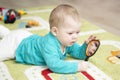 7-month child examines himself in a mirror lying on carpet. Baby boy girl playing with mirror. Portrait Kid Soft Focus Royalty Free Stock Photo