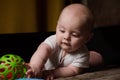 6 month old baby boy. Caucasian infant lying on sofa playing with plastic toy. Early childhood development. Royalty Free Stock Photo