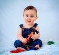 6-month-old baby boy dressed in denim overalls while playing tool worker. He looks like a little carpenter or a little plumber Royalty Free Stock Photo