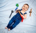 6-month-old baby boy dressed in denim overalls while playing tool worker. Royalty Free Stock Photo