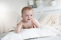 9 month old baby crawling over pillows on bed Royalty Free Stock Photo