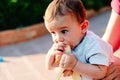 6 month old baby nibbling a banana in his garden