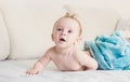 9 months baby boy under blue towel on bed with white sheets Royalty Free Stock Photo