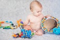 baby lying on Developing rug. playing in Mobile. educational toys. Sweet child Crawling And Playing With Toys On Carpet Royalty Free Stock Photo