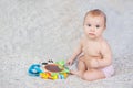 baby lying on Developing rug. playing in Mobile. educational toys. Sweet child Crawling And Playing With Toys On Carpet Royalty Free Stock Photo