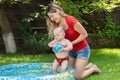 Cute 10 months old baby boy enjoying swimming in inflatable pool at house backyard Royalty Free Stock Photo