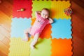 4 months old baby girl lying on colorful play mat