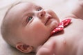 4 months old infant baby boy at changing table, detail on his head, red white dot bow over neck Royalty Free Stock Photo