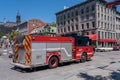 Red firetruck driving on De la Commune street in Old Montreal