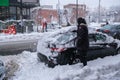 Man shovelling and removing snow from car in Montreal