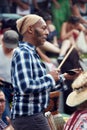 African American male percussionist playing rhythm with a cow bell at Tam Tams festival in Mount Royal Park