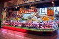 Canadian workers cutting and preparing meat behind the counter at Adelard Belange butcher shop at Atwater market in Montreal,