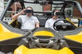 Two men seating in a real car and wearing virtual reality headsets