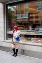 Young Asian teenage schoolgirl posing in front of a cafe